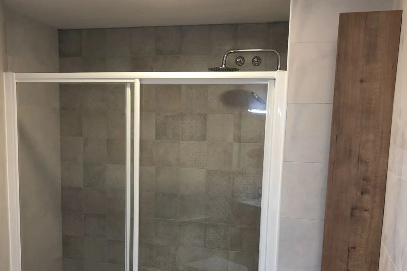 Dutxa d’obra enrasada amb el paviment i mampara corredissa de vidre
