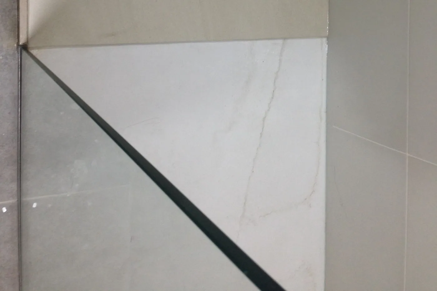 Plat de dutxa d’obra revestit amb porcellànic marbrat de gran format