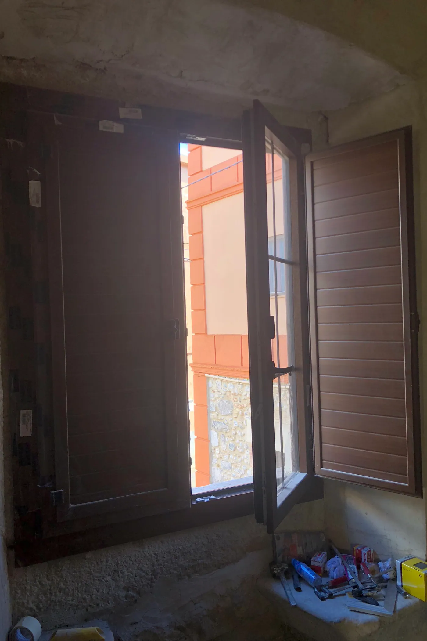Finestra nova encastada en un mur de pedra de gran gruix amb ampit interior