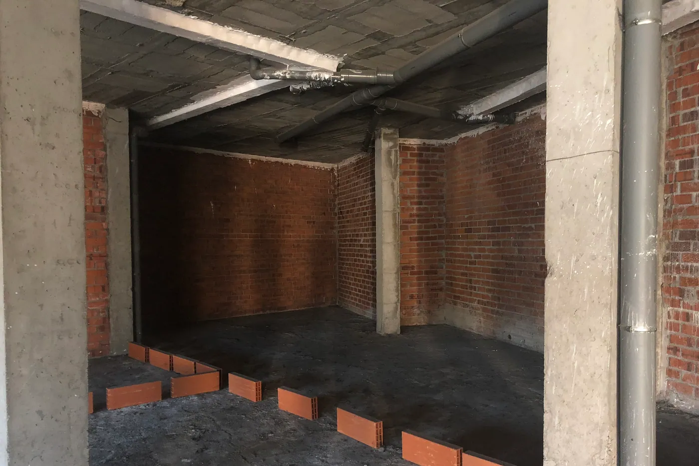 Local en brut amb estructura de formigó vista abans de l’adequació