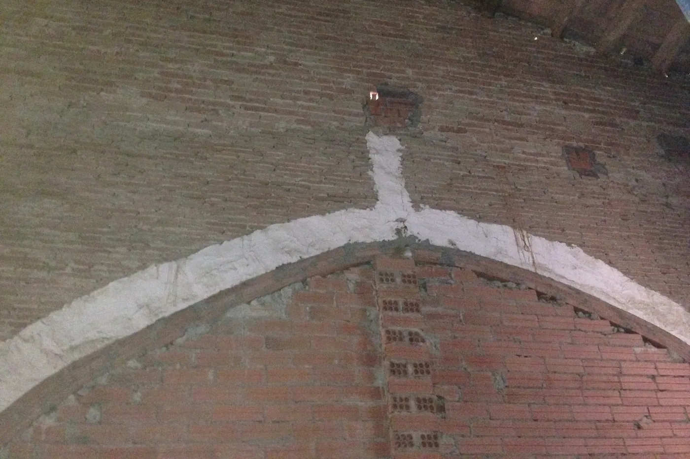 Arc de mig punt de maó massís sota encavallada de fusta en un paller