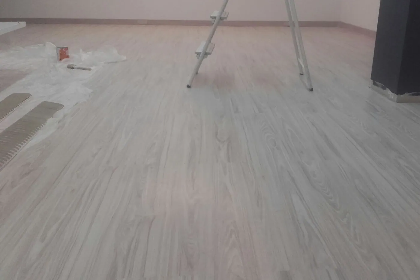 Lames de parquet laminat col·locades en un habitatge reformat, amb junta perimetral i sòcol acabat